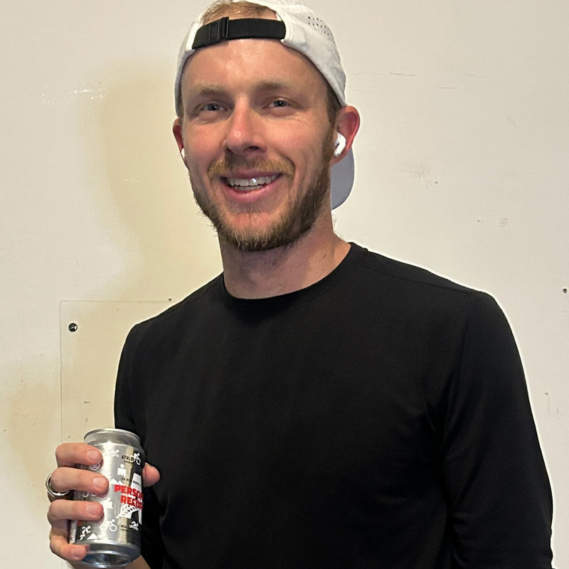 Professional triathlete Ben Kanute holding a Personal Record IPA.