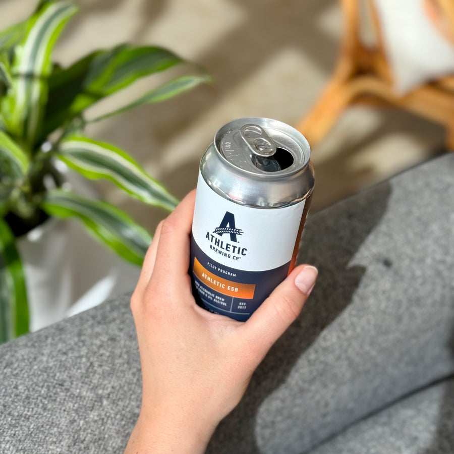 holding an opened can of Athletic ESB beer
