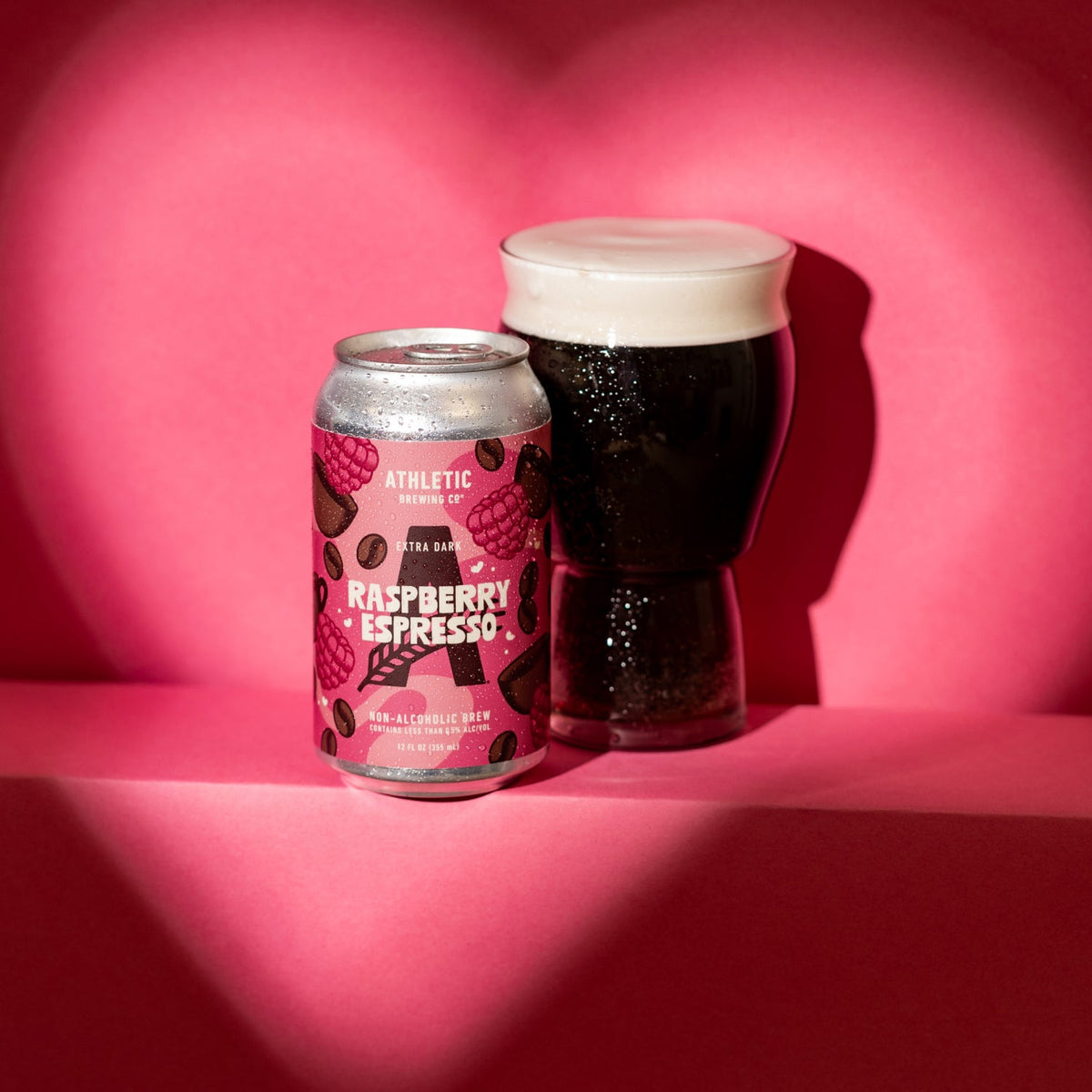 Raspberry espresso can and a glass of the extra dark beer in a hear shapped scnario 